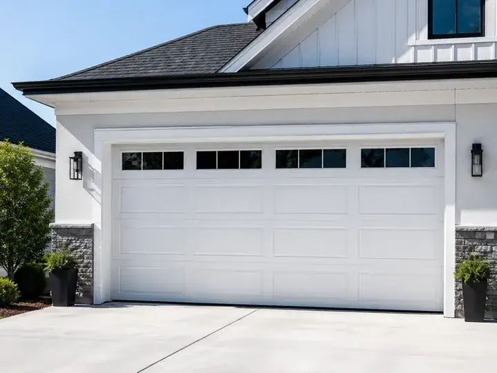 Newly installed white long-panel garage door with window inserts