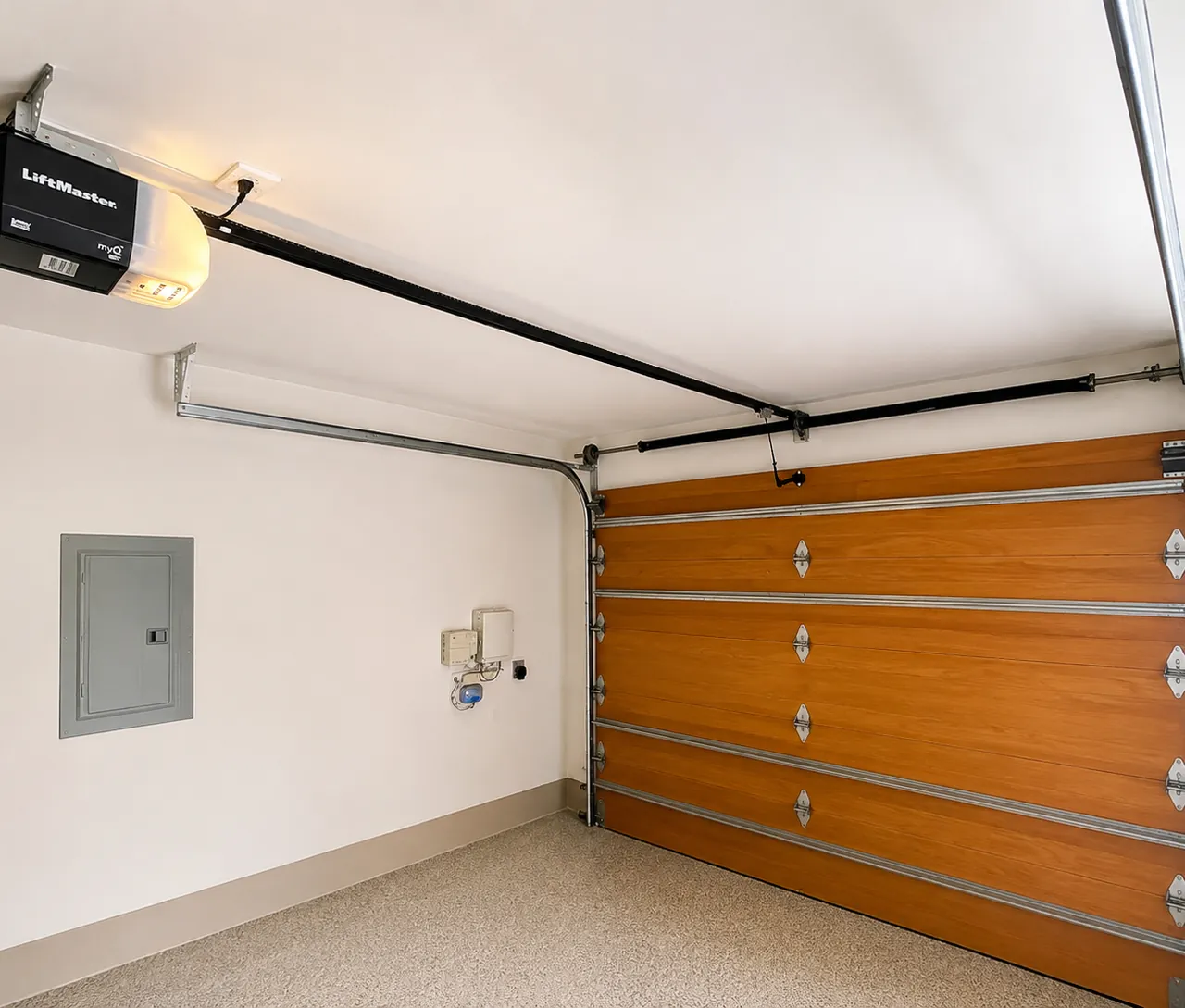 Wood-finish sectional garage door with a LiftMaster ceiling opener installed by Top Level Garage Doors